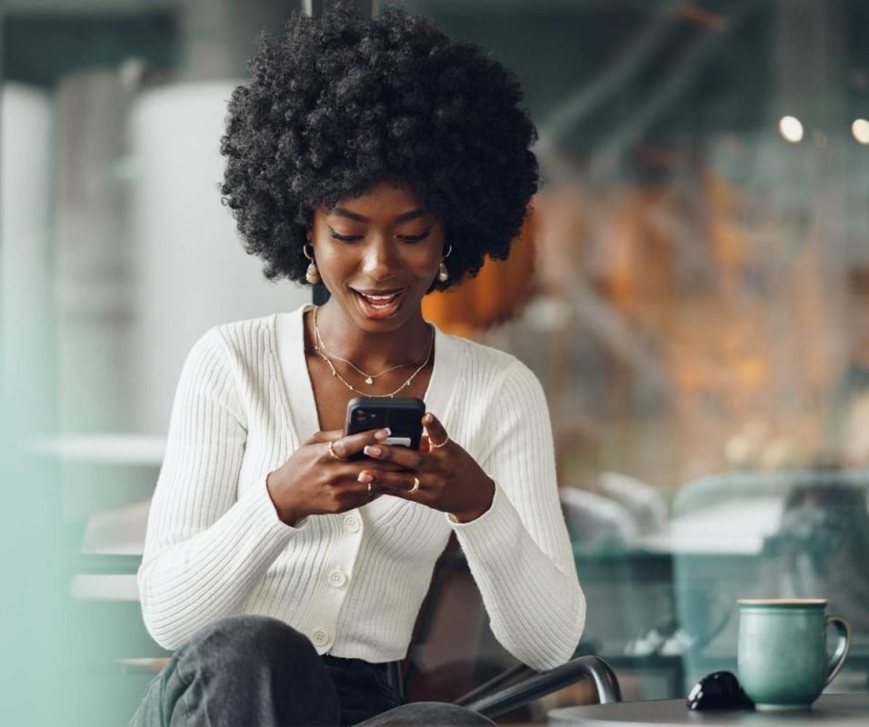 portrait-beautiful-young-african-woman-using-her-cellphone-cafe (1) (1)